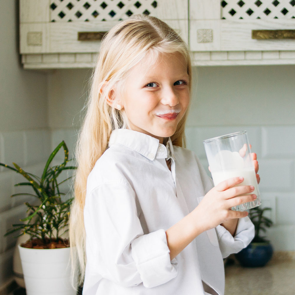 happy blonde long hair little girl drinking milk i LNUQ2ZH