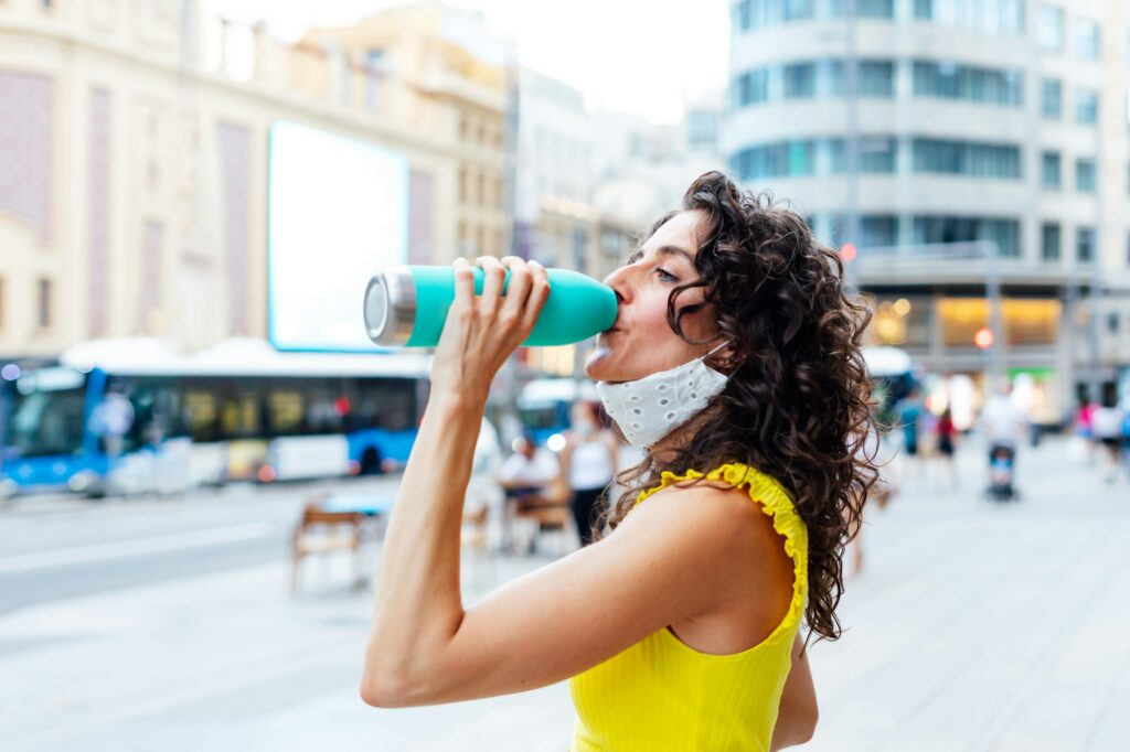 Woman drinking water in the street