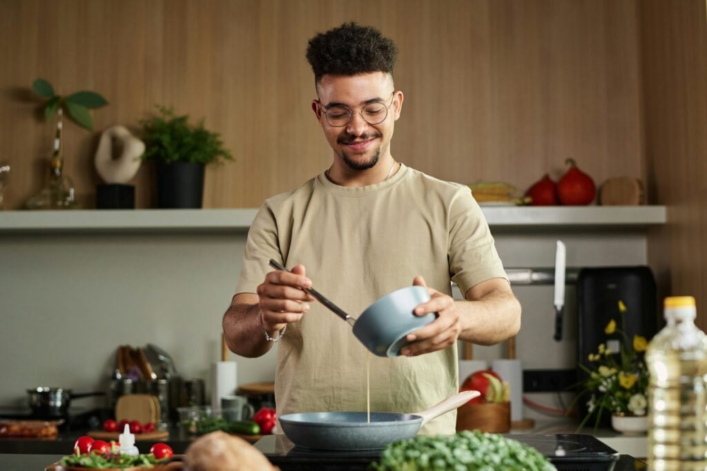 Man Pouring Egg Liquid on Pan