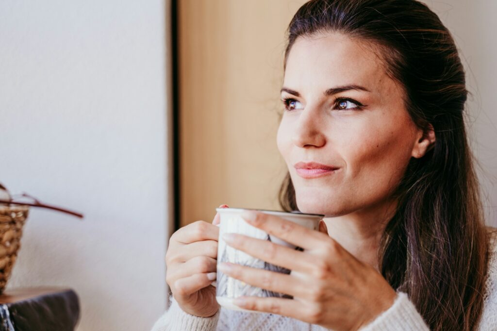 woman having a cup of tea at home during breakfast. Healthy breakfast with fruits and sweets